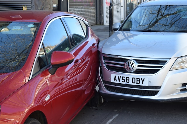 silver car colliding into red car from behind